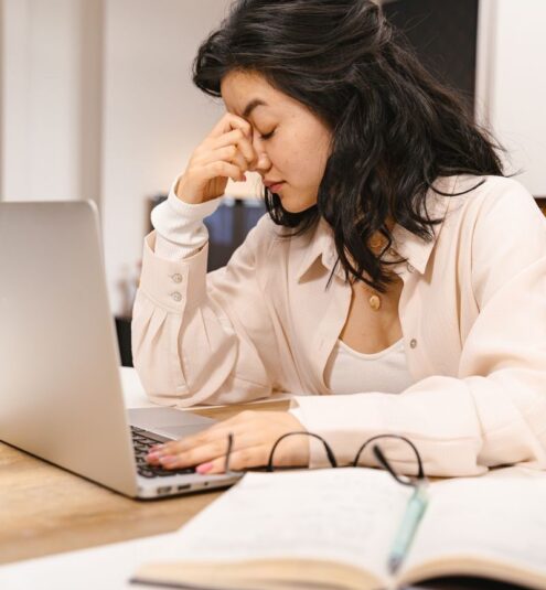 Photo by AI25.Studio AI GENERATIVE Woman with closed eyes feeling frustration while working on a laptop indoors.